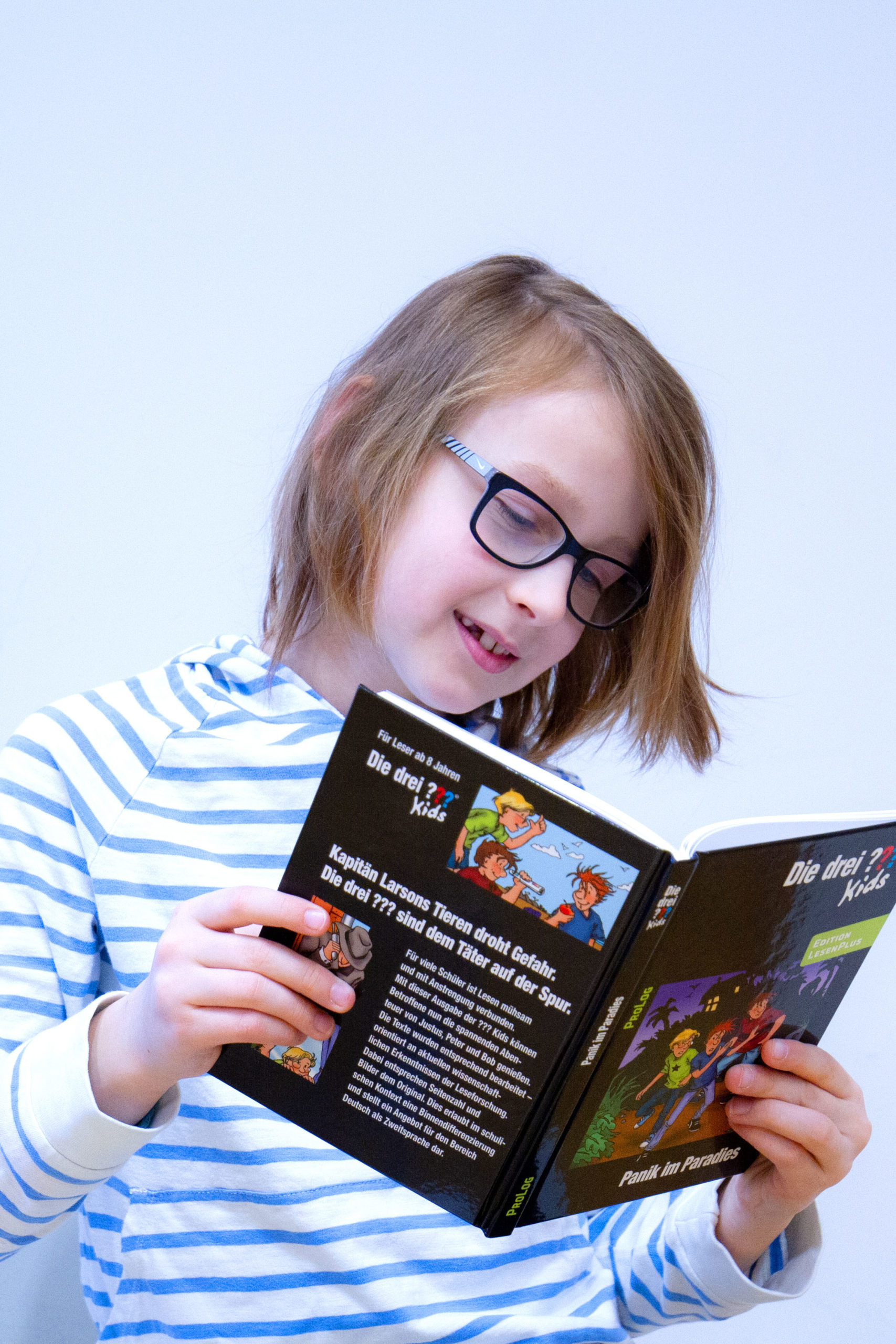 Mädchen liest Die drei Fragezeichen Kids EditionLesenPlus
