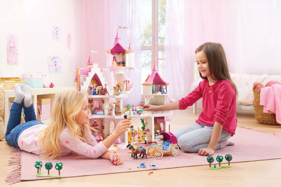 Mädchen spielen mit dem Prinzessinnenschloss von Playmobil