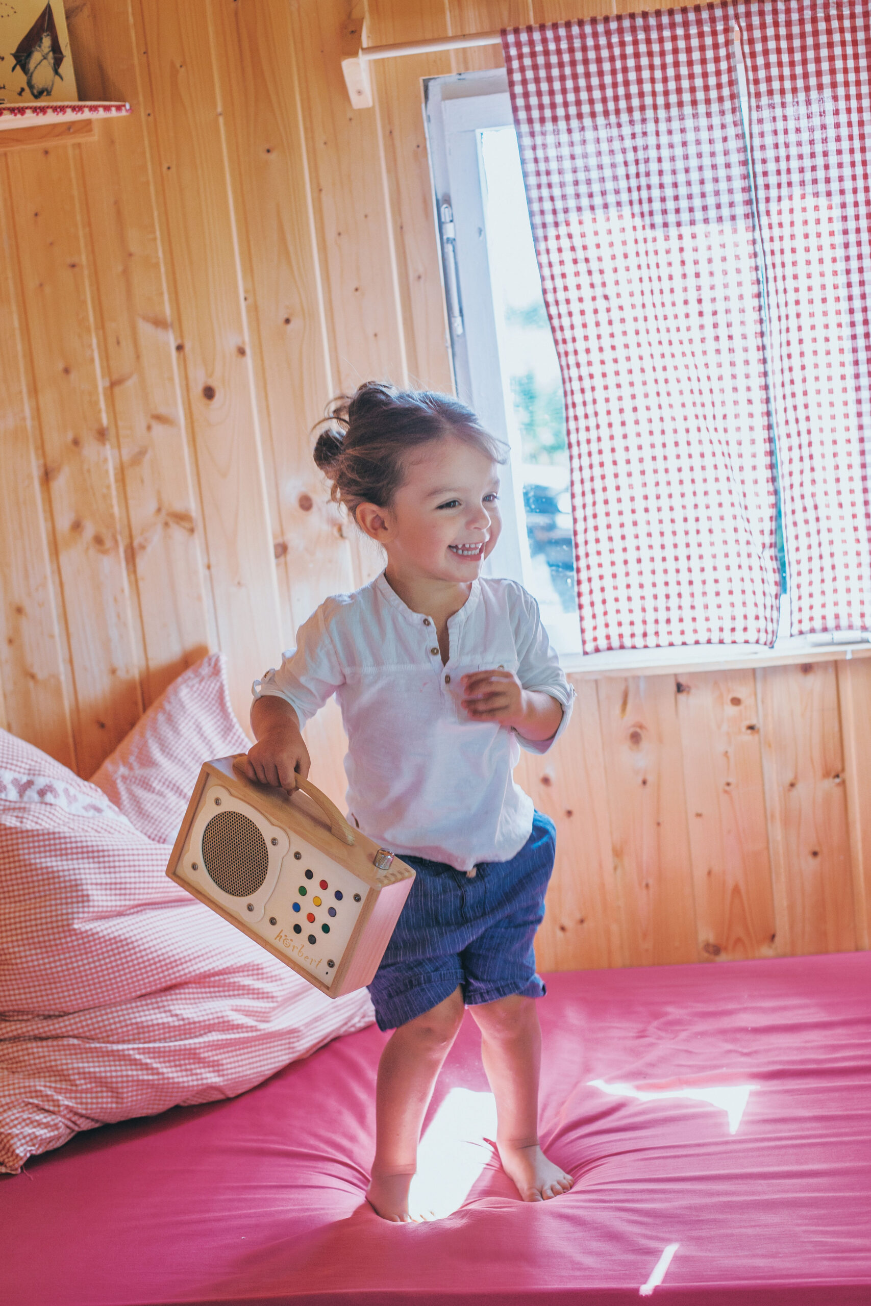 Mädchen spielt mit MP3-Player aus Holz